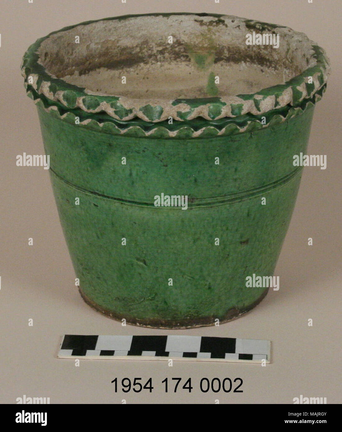 Green-glazed earthenware flowerpot, white clay glazed with green glaze. Rim has double scalloped decoration. Made by St. Charles potter Joseph Oser. Title: Earthenware Flowerpot Made by Joseph Oser  . circa 1870. Oser Pottery Stock Photo