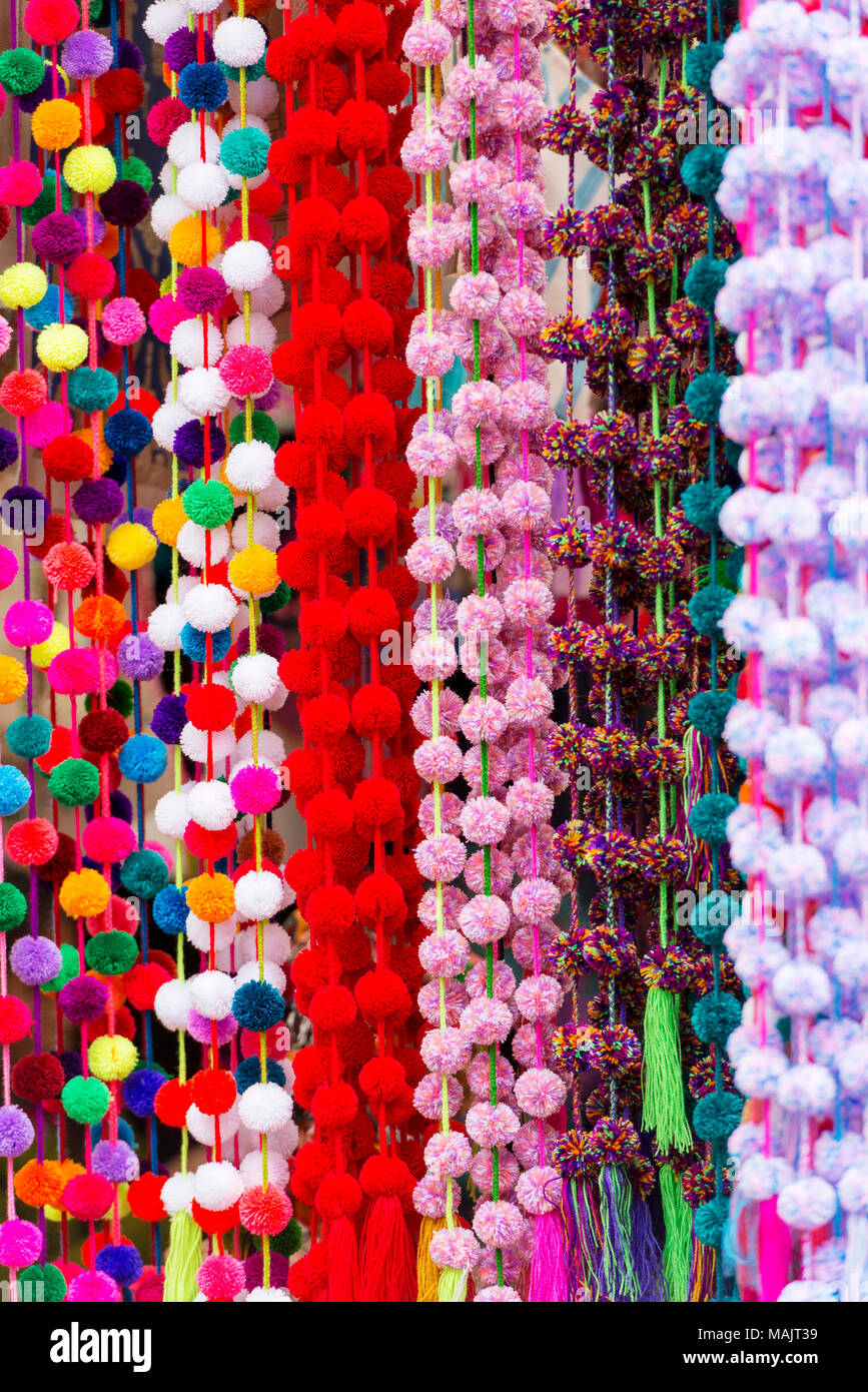Colorful decorative pom-poms hanging in a Chiapas market as a background texture Stock Photo