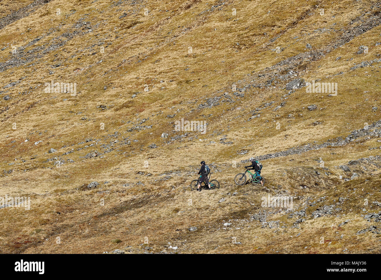 Couple cycling on mountain track Stock Photo