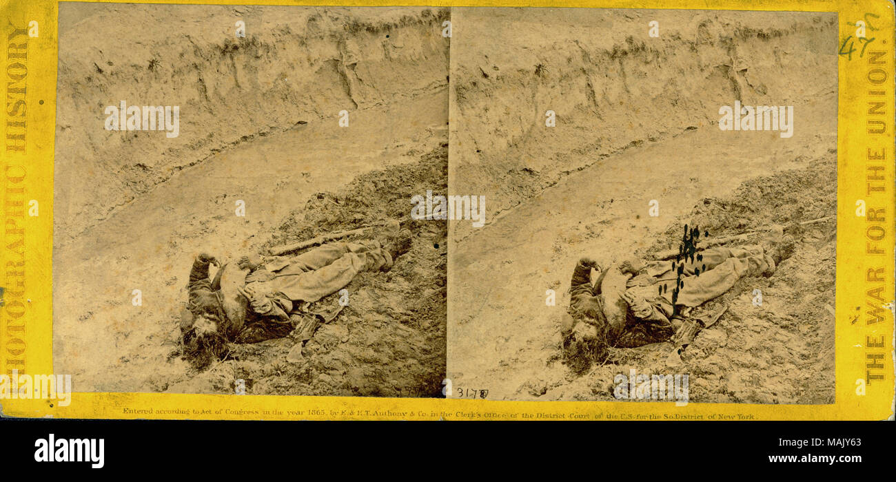 Photograph of dead Confederate soldier lying in a ditch. 'PHOTOGRAPHIC HISTORY THE WAR FOR THE UNION' (printed vertically on obverse side). 'WAR VIEWS C. S. Soldier killed by a shell in the Trenches of Fort Mahone, called by the Soldiers 'Fort Damnation.' This view was taken the morning after the storming of Petersburg, Va., April 2d, 1865.' (printed on reverse side). Two cent stamp on reverse side. Title: Confederate soldier killed by a shell in a trench at Fort Mahone near Petersburg, VA.  . 2 April 1865. Stock Photo