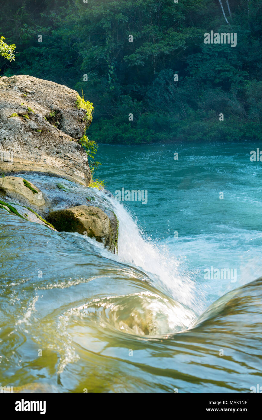 Water flowing from waterfall in forest of Rio Blanco National Park in Toledo Belize Stock Photo