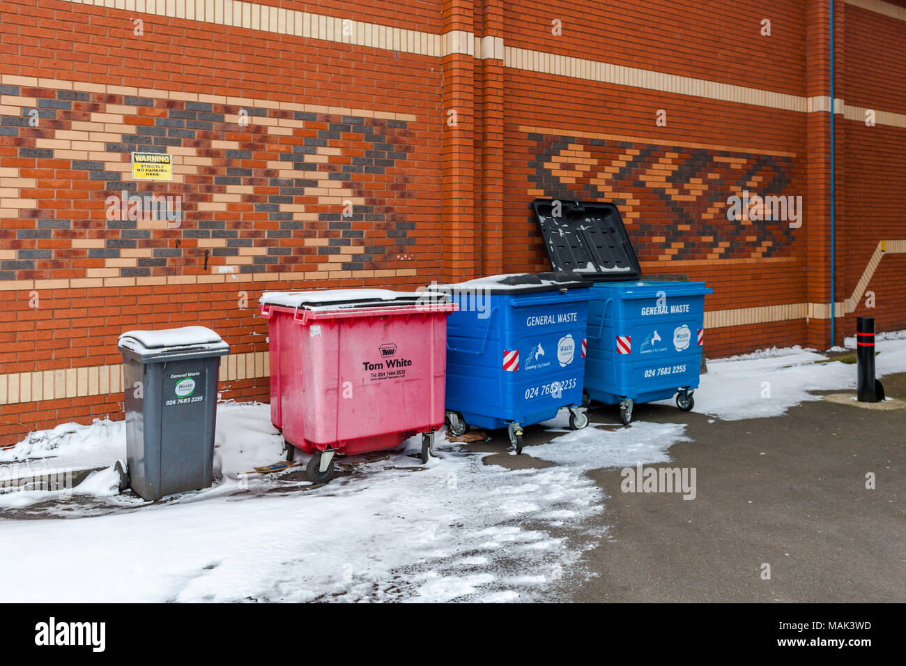 Industrial wheelie bins in snow in Coventry City Centre, West Midlands, UK. Stock Photo