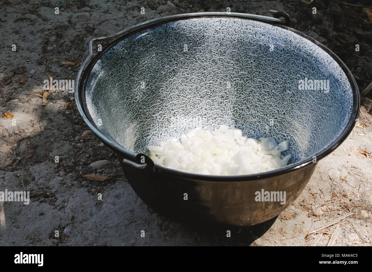 Black Cauldron with White Diced Onion on the Ground Stock Photo