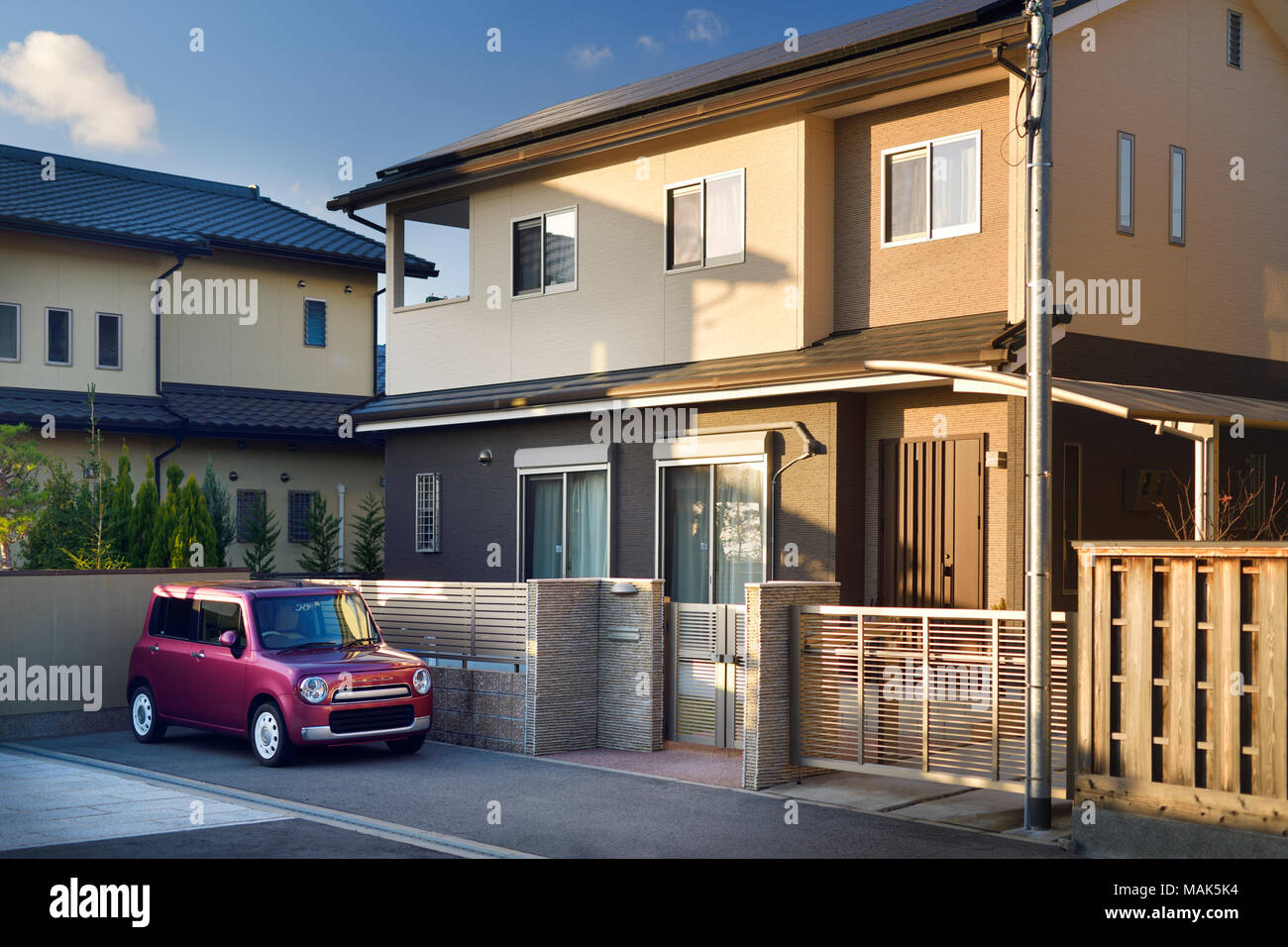 Modern Japanese private residential house exterior with a small car Suzuki Lapin parked on the driveway. Uji, Kyoto prefecture, Japan 2017. Stock Photo