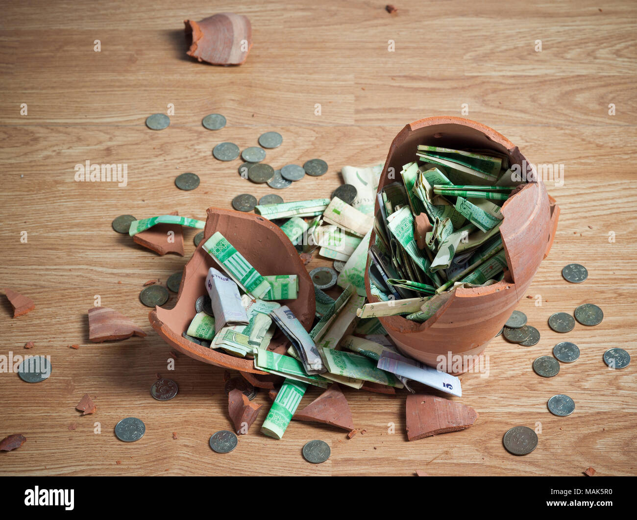 Broken money box, with Saudi Riyal banknotes and coins Stock Photo - Alamy