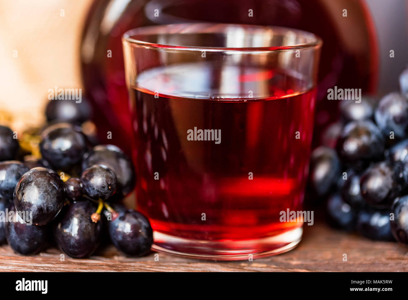 Red grape juice in glass and grapes close Stock Photo Alamy