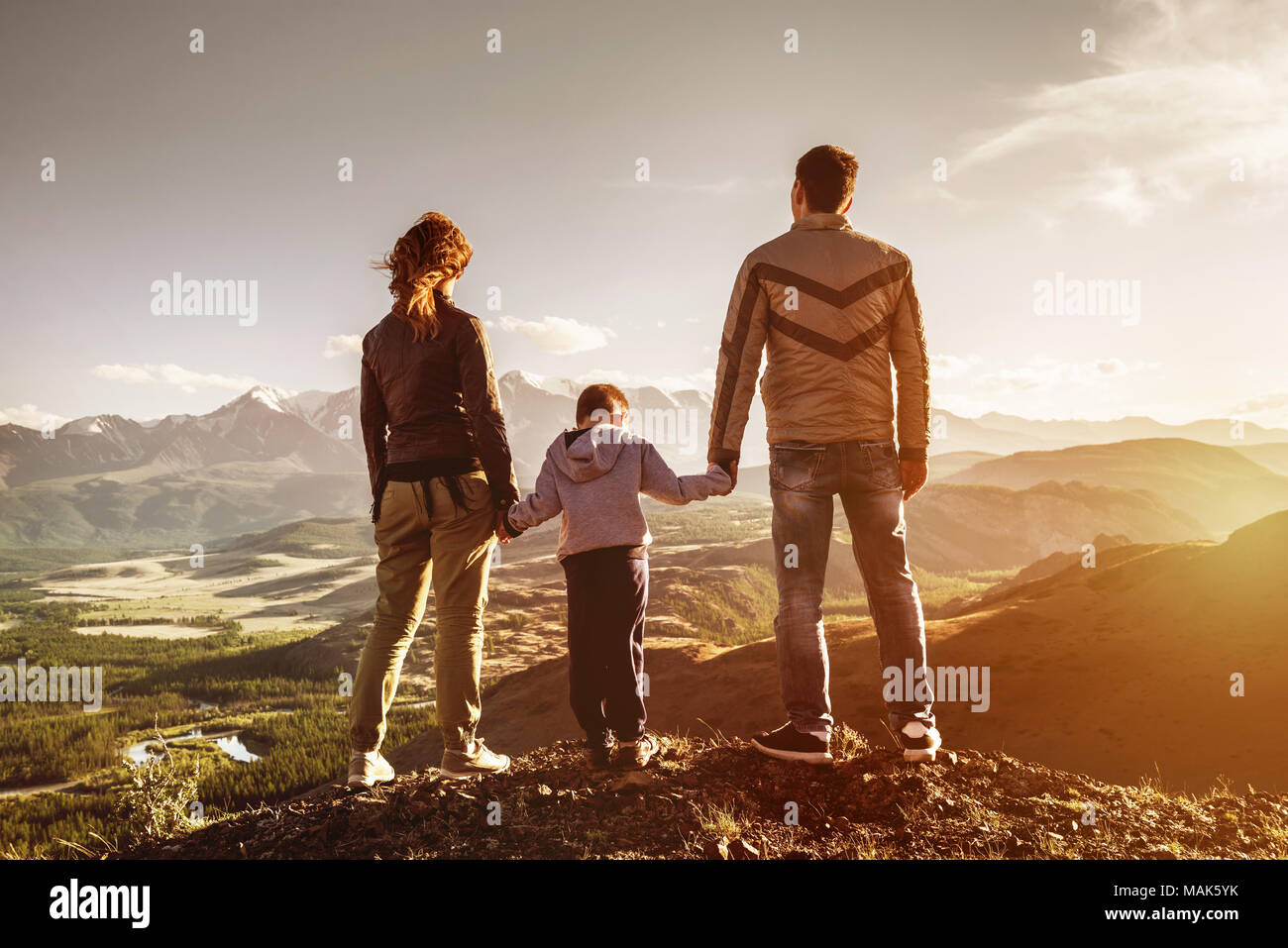Family with son stands mountains sunset Stock Photo