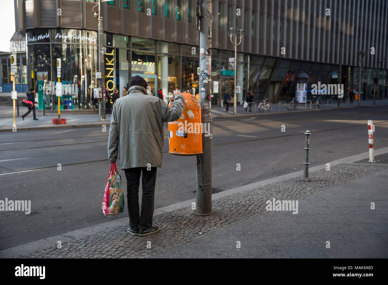 A man taking something out of a bin in Berlin, Germany. Stock Photo