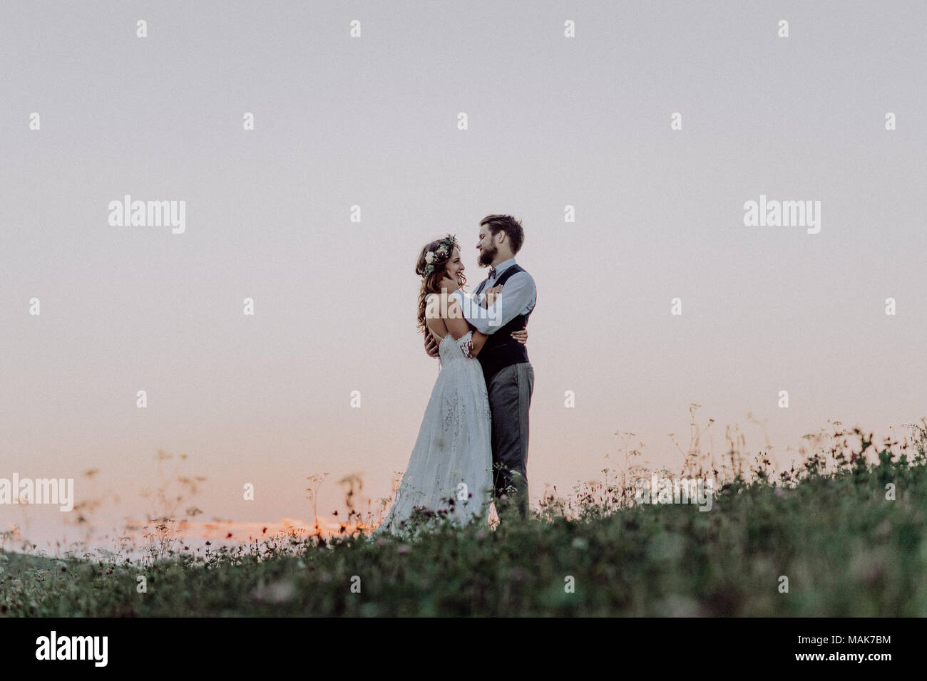 Beautiful bride and groom at sunset in green nature Stock Photo - Alamy