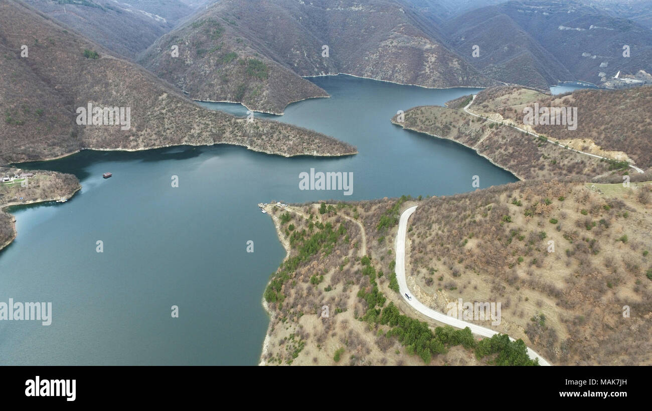 Aerial landscape view of a meandering big river lake and road in the mountain Stock Photo