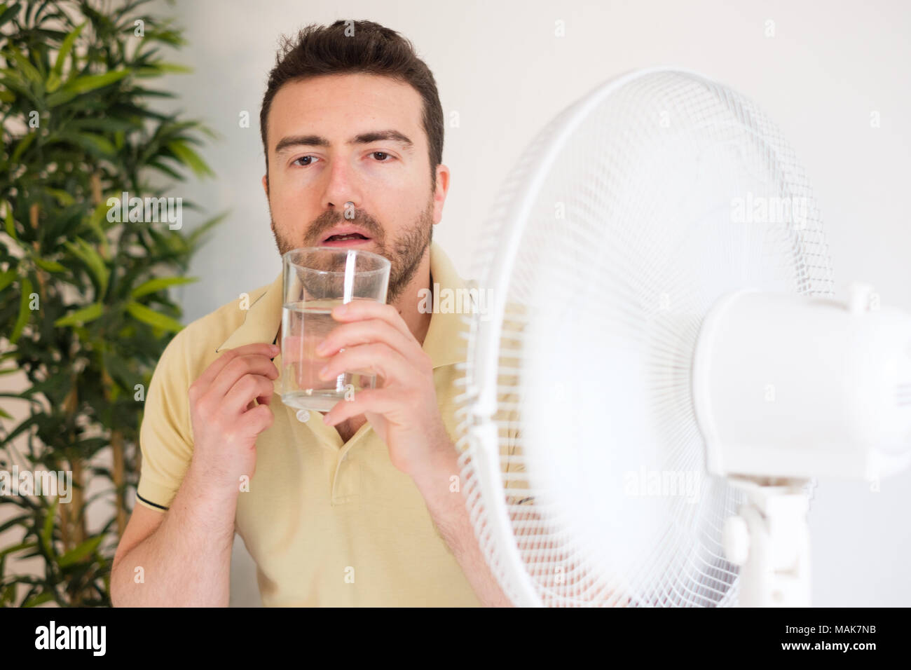 Young man suffering from summer heat and high humidity level Stock