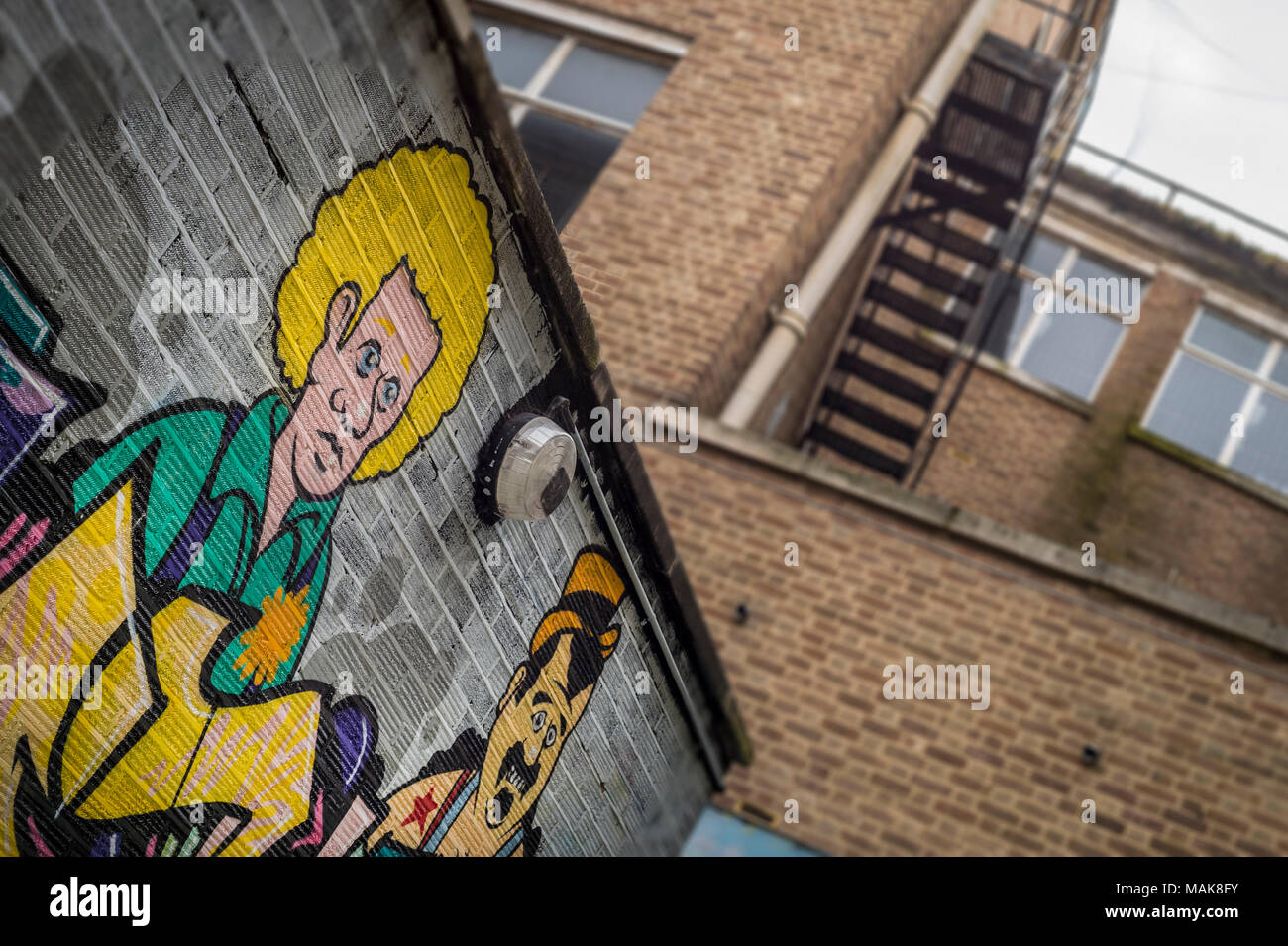 brick walls covered in cartoon graffiti and street art. Stock Photo