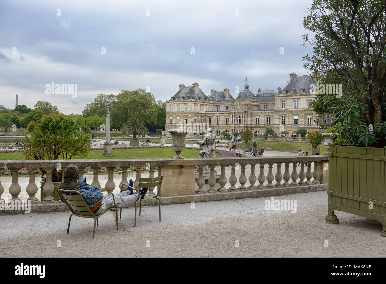 A young man rests on chairs in the Luxembourg Garden, Paris Stock Photo