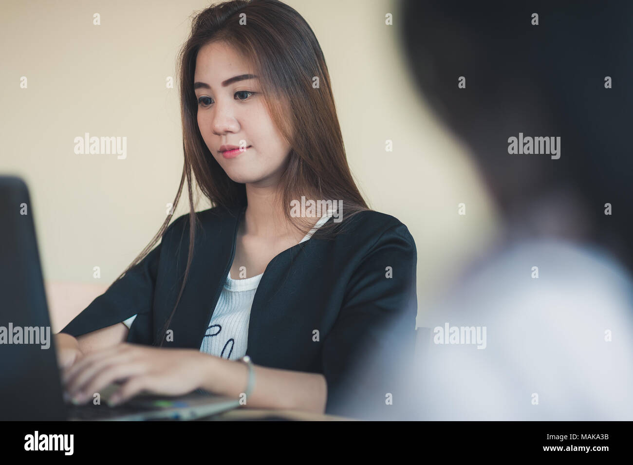 Young Asian secretary female working with laptop computer in office. Business people lifestyle on workday Stock Photo