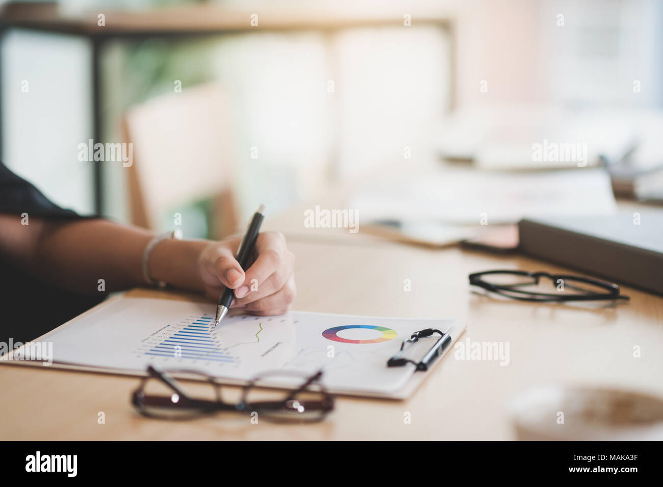 Woman hand writing some idea on clipboard while sitting in meeting room. Business lifestyle on workday Stock Photo