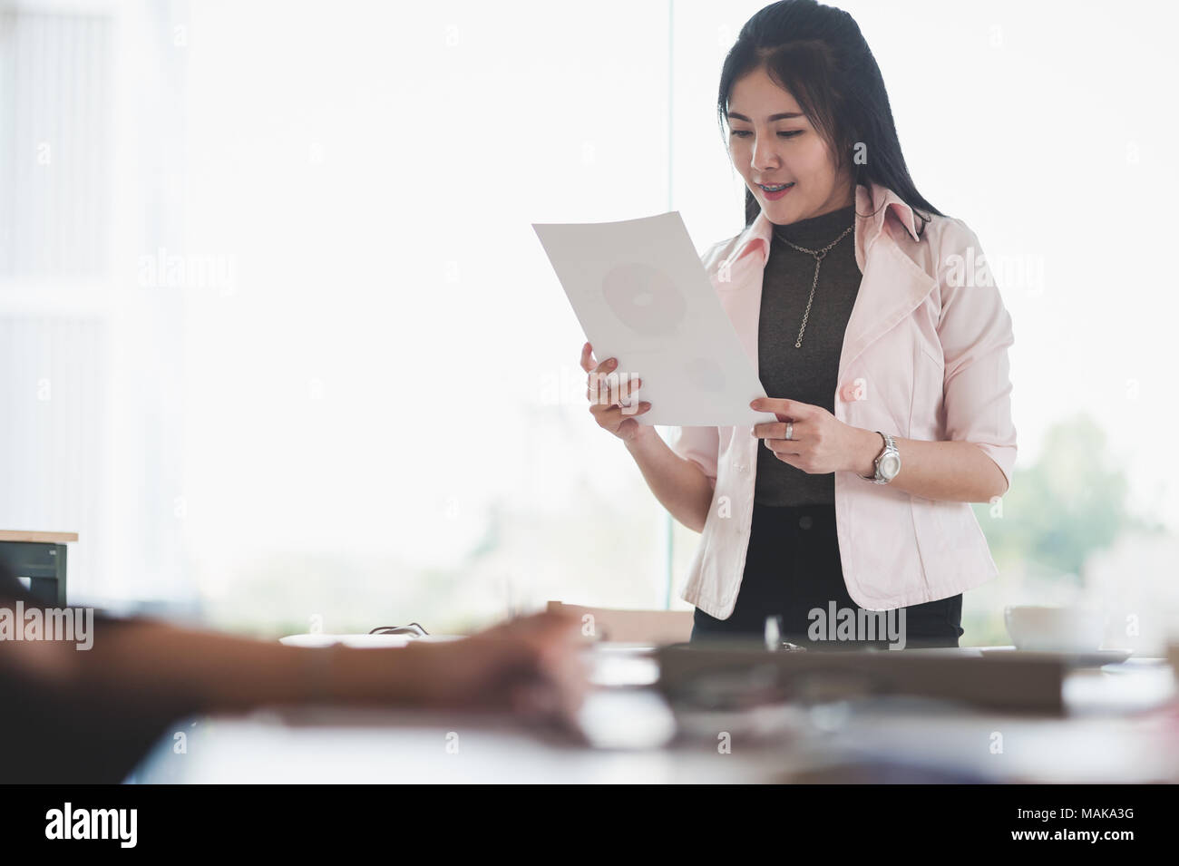 Young Asian executive female manage paperwork in meeting room. Business people lifestyle on workday Stock Photo