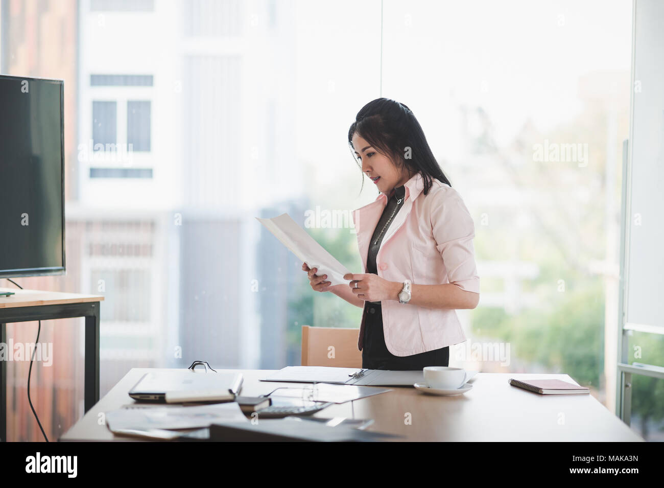 Young Asian executive female manage paperwork in meeting room. Business people lifestyle on workday Stock Photo