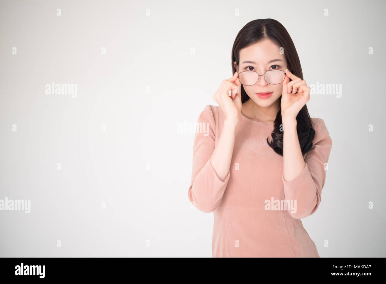 Eye problems concept such as near-sighted, myopia, far-sighted, astigmatism, cataract, glaucoma, ophthalmology, optometry. Asian woman holding eyeglas Stock Photo