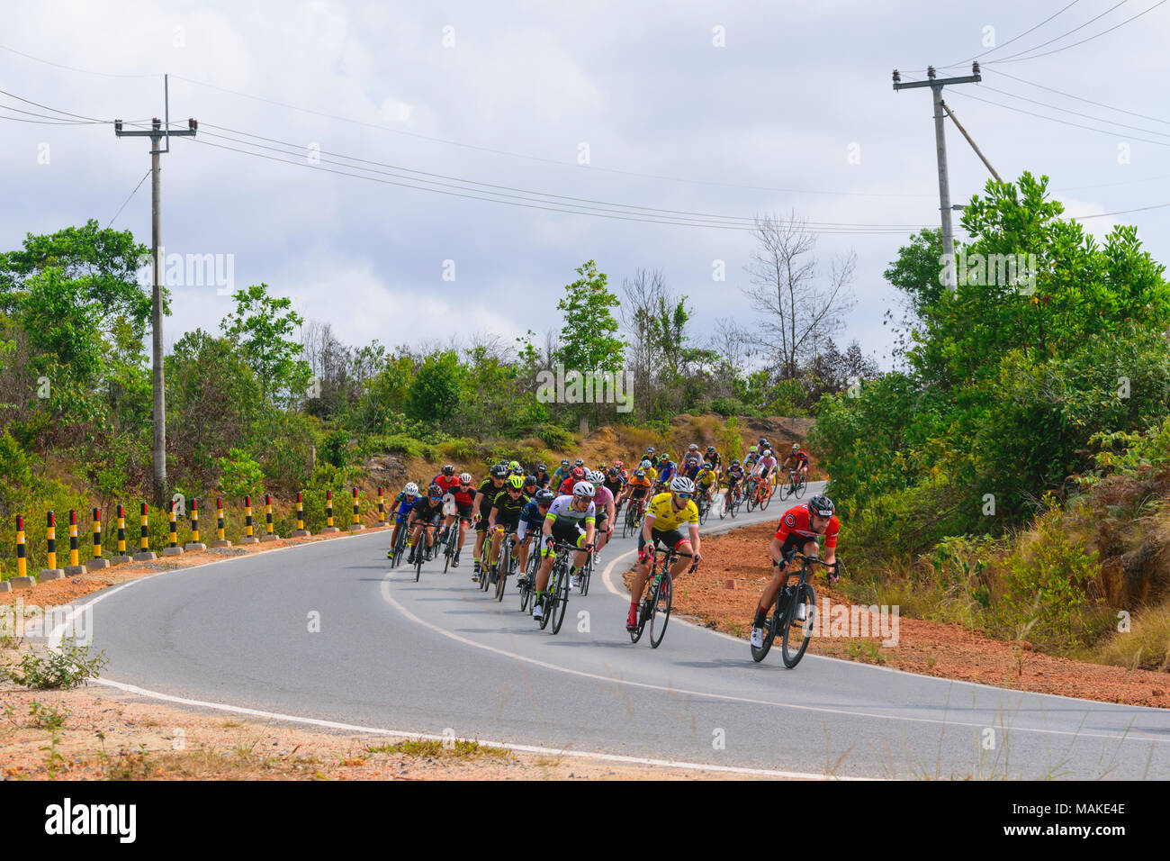 march 24, 2018 - cyclists participants Tour de bintan 2018 (144 km) are crossing the plantations Toapaya and Galang batang, bintan island - Indonesia Stock Photo