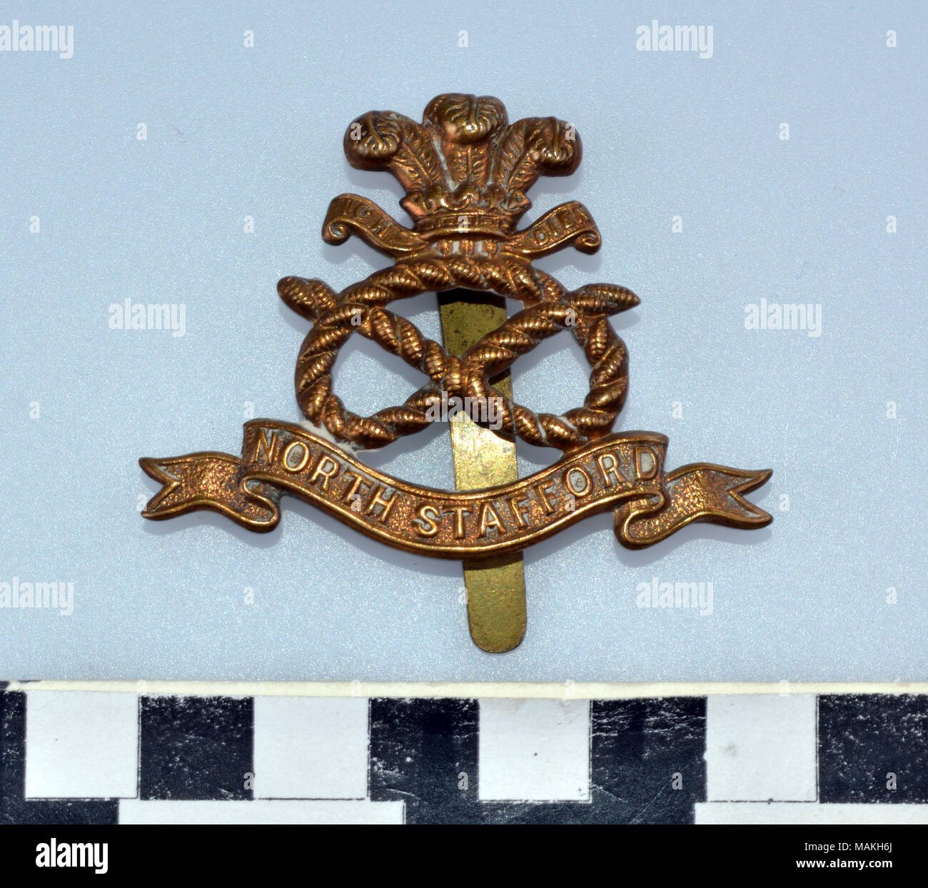 World War I North Staffordshire Regiment brass hat badge consisting of a knotted rope topped by the Prince of Wales's Feathers overa banner embossed NORTH STAFFORD Title: World War I North Staffordshire Regiment Hat Badge  . after 1914. Stock Photo