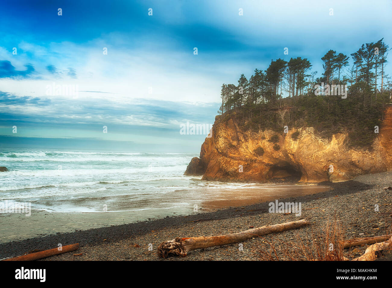 Stormy weather threathens the abandoned beach at Hug Point, Oregon.  The majectic landscape of sculptured shoreline topped with wind shaped trees and  Stock Photo