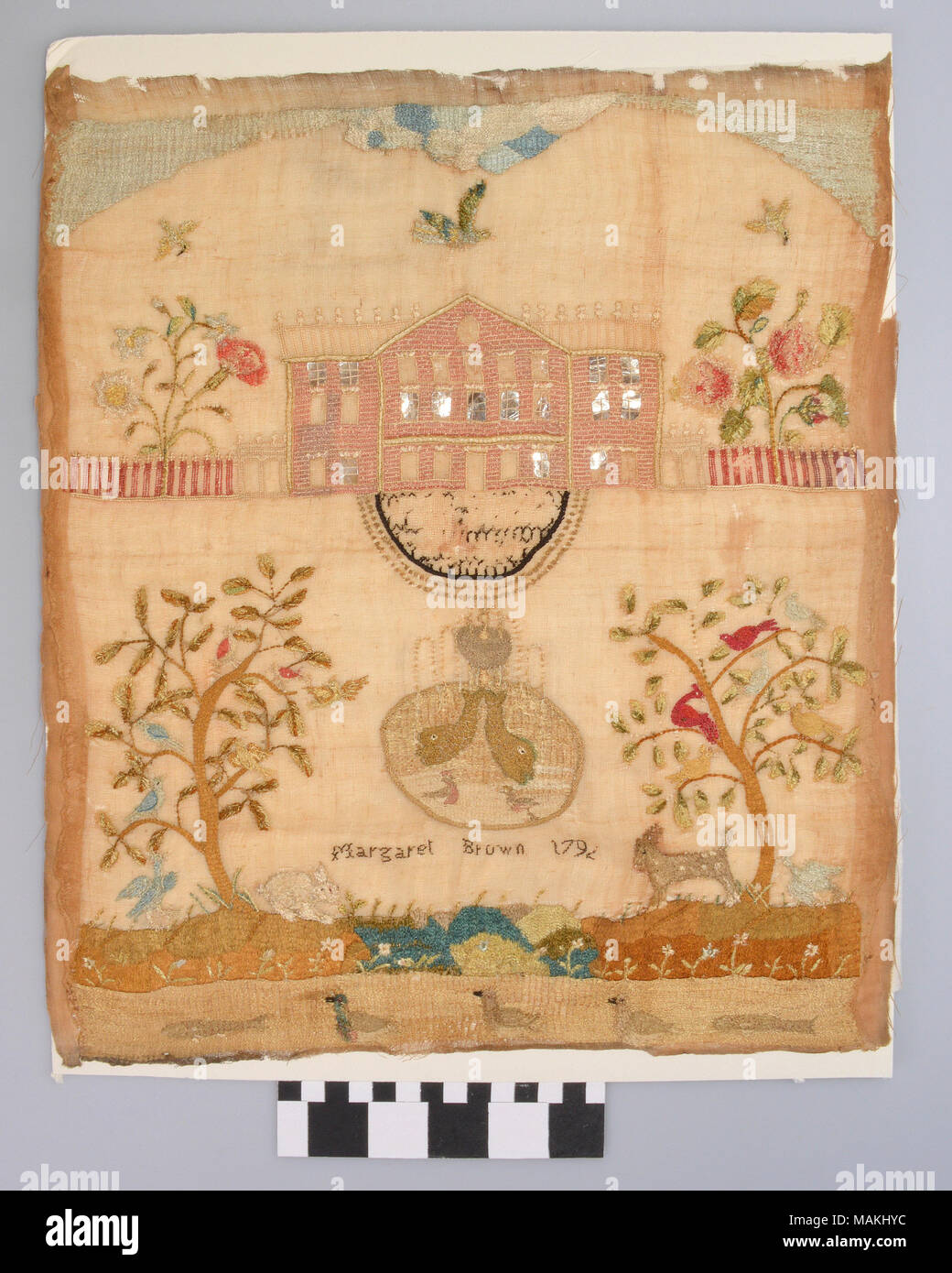 Elaborate embroidery with an image of a pink house and trees with various animals. Created by Margaret Brown in 1792. Margaret later married James Austin, a distant cousin to Moses Austin. Margaret and James moved to Missouri with other members of the Austin family after their marriage. Title: Embroidery of Margaret Brown  . 1792. Margaret Brown Stock Photo