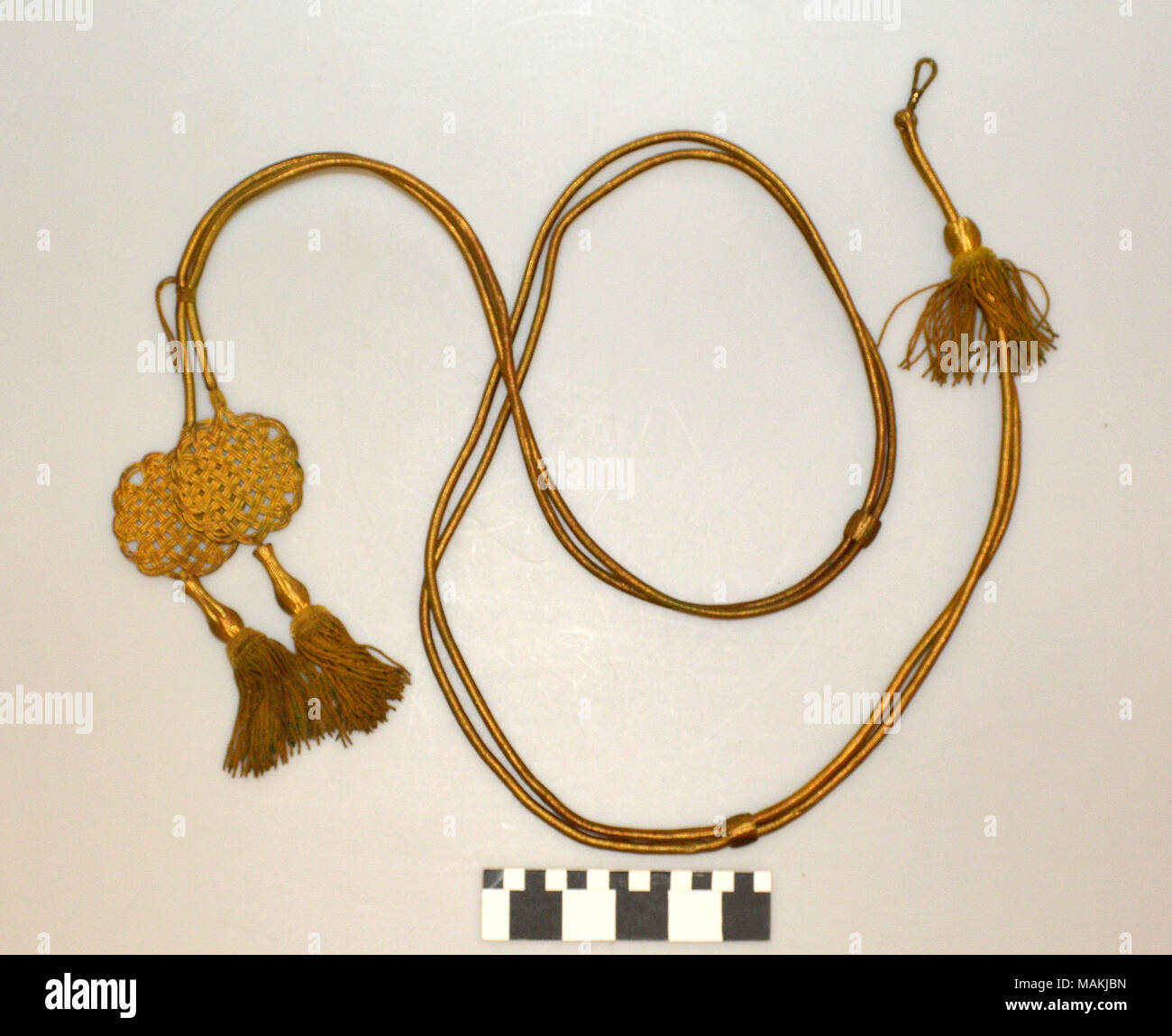 Gold aiguillette with round woven details and tassels at the ends. Title: Gold Aiguillette  . between 1840 and 1860. Stock Photo