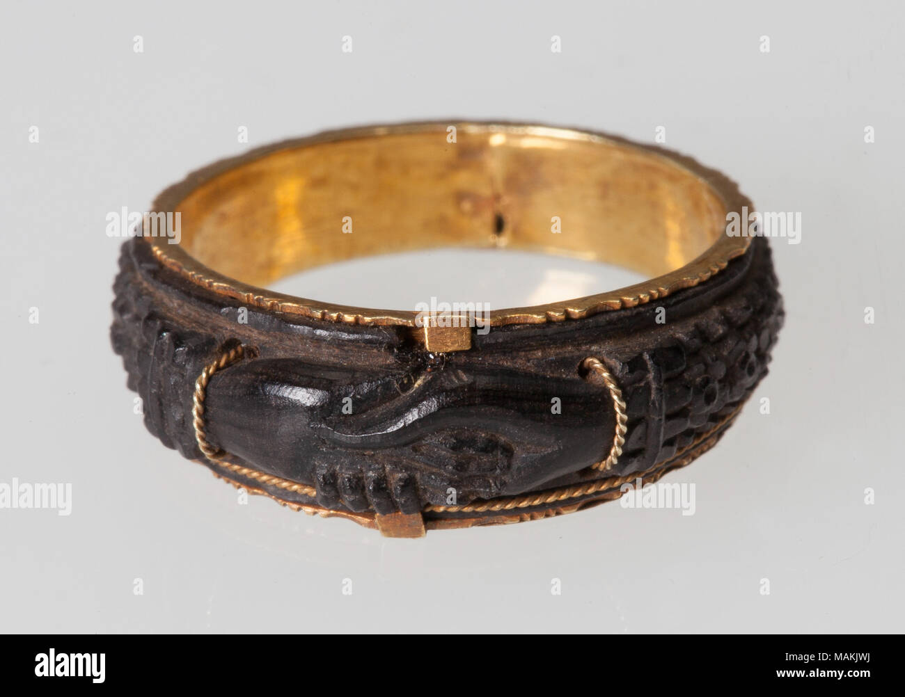 Molded mourning ring with gold band. Features an image of two clasped hands. Title: Mourning Fede Ring  . between 1850 and 1900. Stock Photo