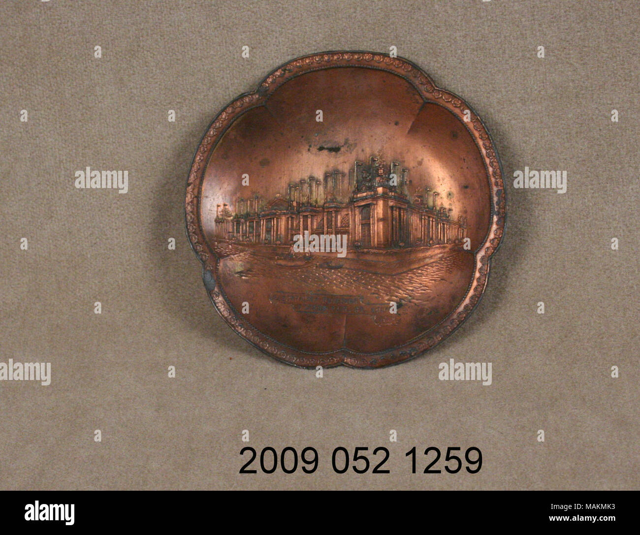 Copper colored metal pin tray has scalloped edge and raised image of the Palace of Electricity from the 1904 World's Fair. Title: Metal Pin Tray With Raised Image of the Palace of Electricity  . 1904. Stock Photo