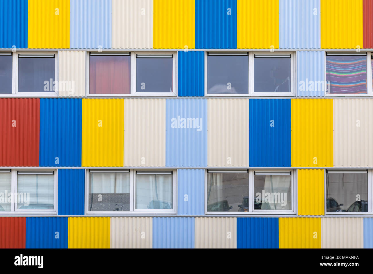 Windows of Student housing in shipping containers painted in pright colors with bicycle parking in the foreground Stock Photo