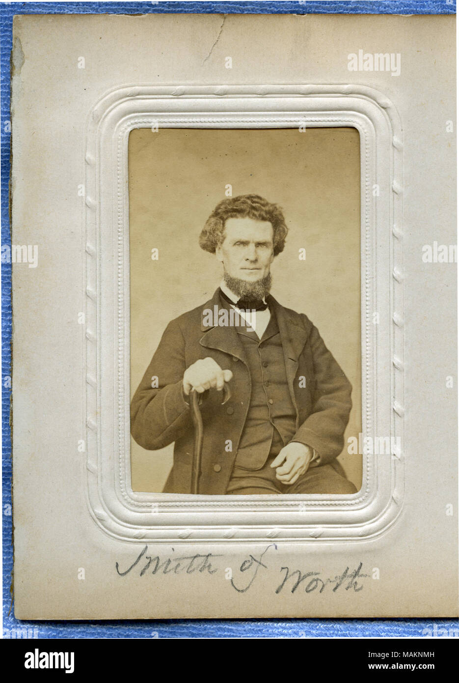 Half-length portrait of a bearded man with curly hair, seated, with cane. Two cent stamp on reverse side. 'Smith of Worth' (written below image on album page). Smith was a delegate from Worth County (12th senatorial district) to the Missouri State Convention held at the Mercantile Library in St. Louis from January 6 to 11, 1865. Title: Eli Smith.  . circa 1865. Stock Photo