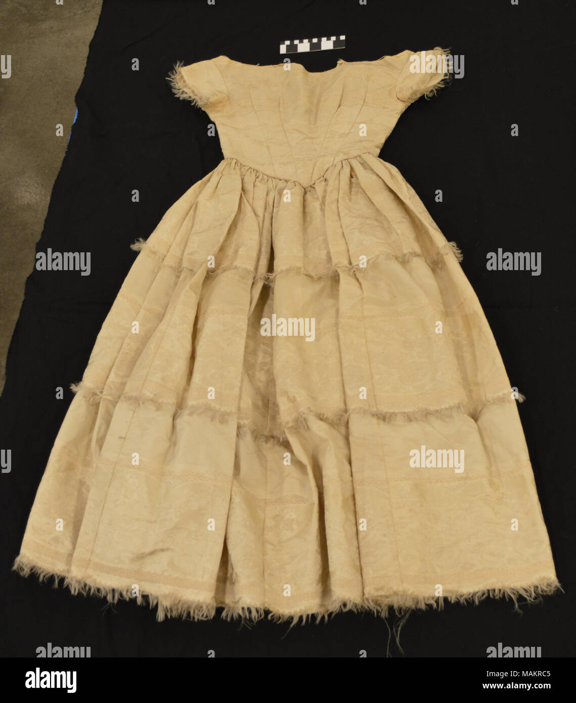 This wedding dress was worn on June 9,1835 by Harriet Elliott Warder when she married William Russell. Warder was the daughter of a Baptist minister in Lexington, Mo. William Russell was a successfully young businessman, and went on to create the short lived Pony Express out of St. Joseph, Missouri in the 1850s. The couple had five children (John, Charles, Anne, Frances, and William) and lived in a 20 room mansion with a stable and a coach house. Russell's later business dealings left him with a tarnished reputation and many debts. After her husband's death, Harriet Russell moved in with her d Stock Photo