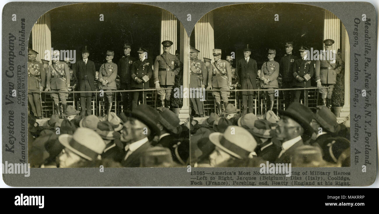 Horizontal, sepia stereocard showing uniformed men standing on a platform. From left to right: General Jacques (Belgium), General Armando Dias (Italy), Vice-President Calvin Coolidge, and Marshall Foch (France). General John J. Pershing is on the far right with Admiral Sir David Beatty (Great Britain) to his right. A crowd of civilians is in the foreground. Keystone Stereograph number 13365. The title reads: 'America's Most Notable Gathering of Military Heroes - Left to Right, Jacques (Belgium), Diaz (Italy), Coolidge, Foch (France), Pershing, end, Beatty (England at his Right). Title: 'Milita Stock Photo