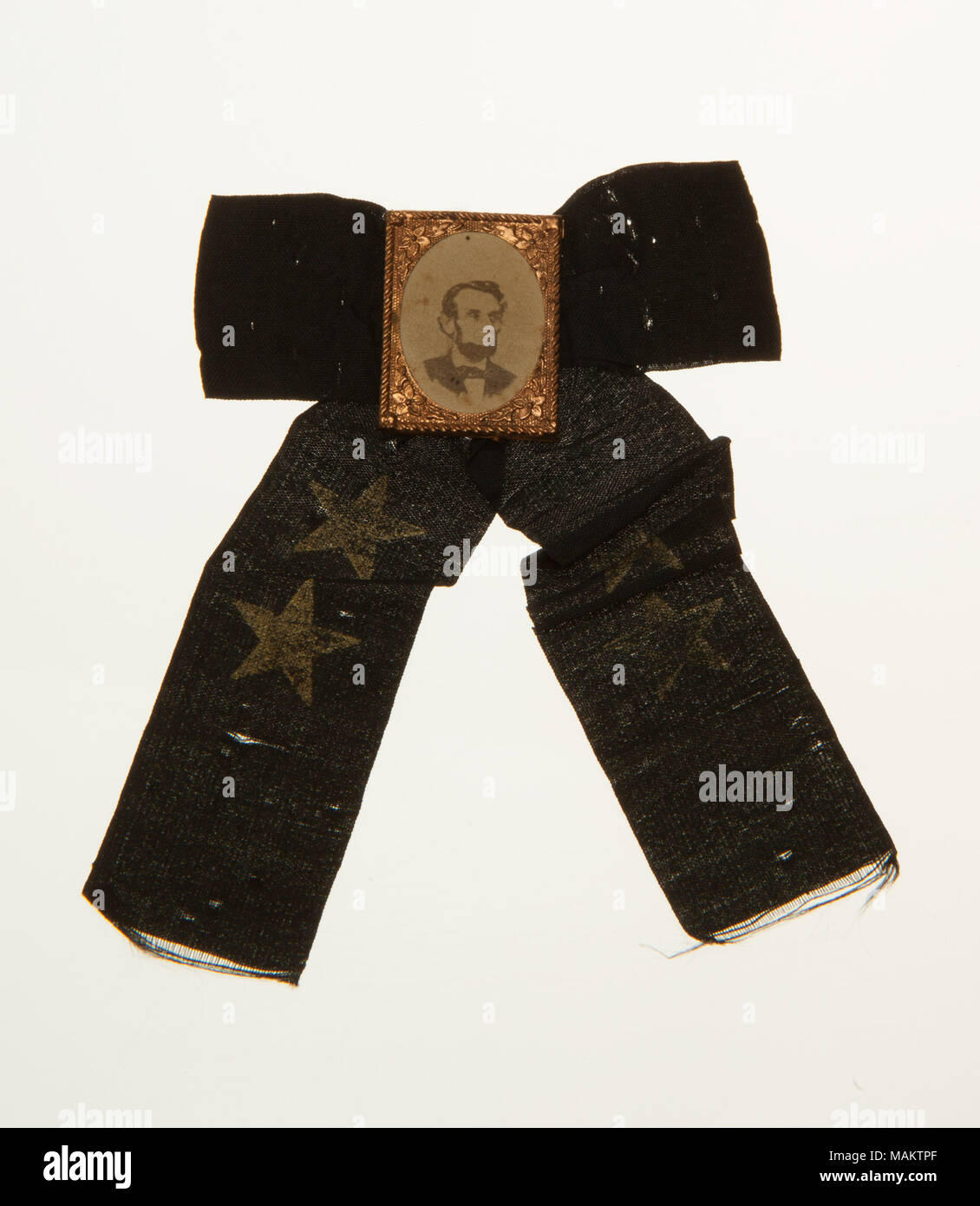 A black ribbon mourning badge with a small photographic image of Abraham Lincoln. Title: Mourning Badge for Abraham Lincoln  . 1865. Stock Photo