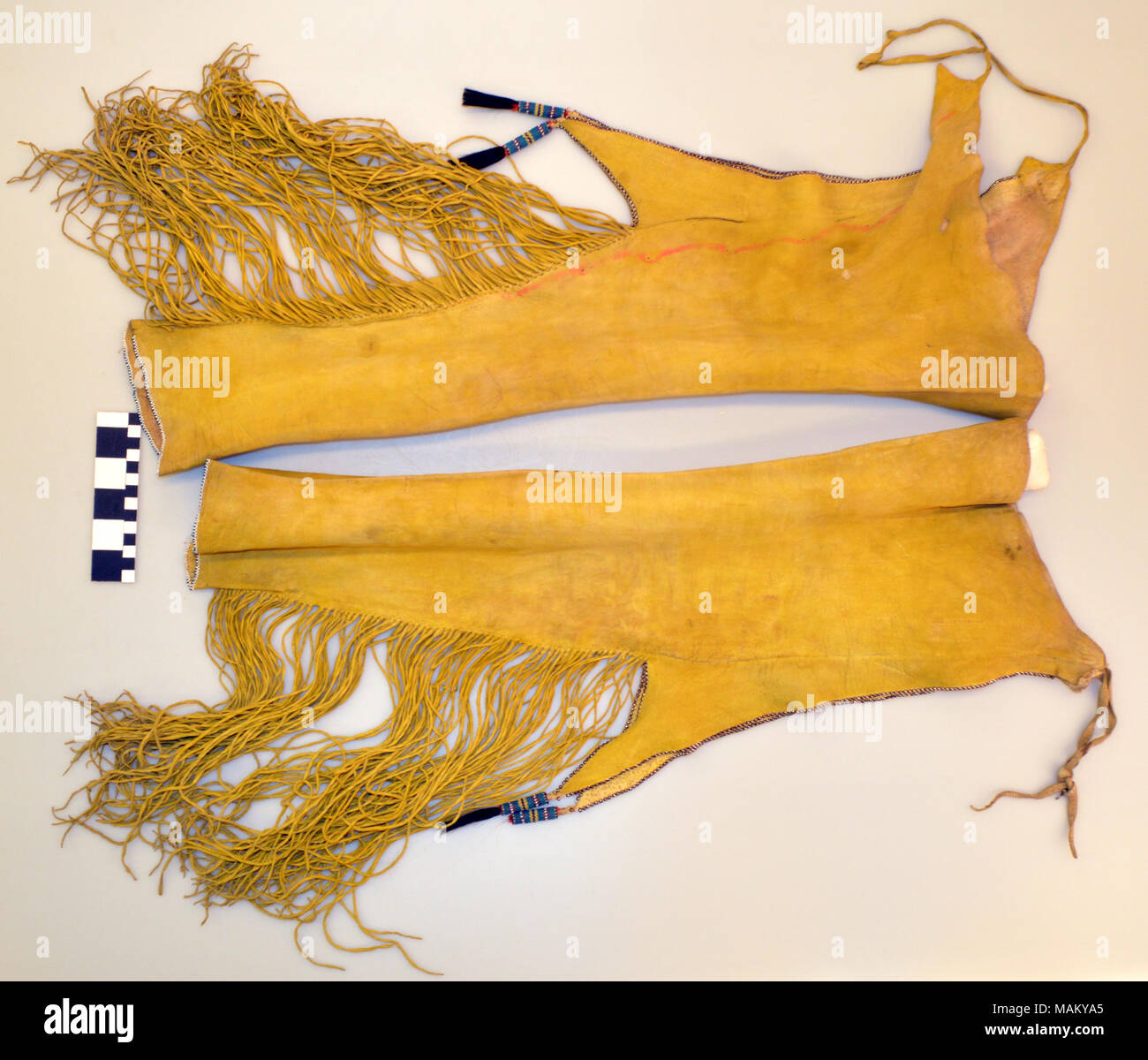 Long leather Comanche leggings with beads and fringe and covered with yellow pigment. Title: Comanche Fringed Leggings  . between 1850 and 1920. Stock Photo