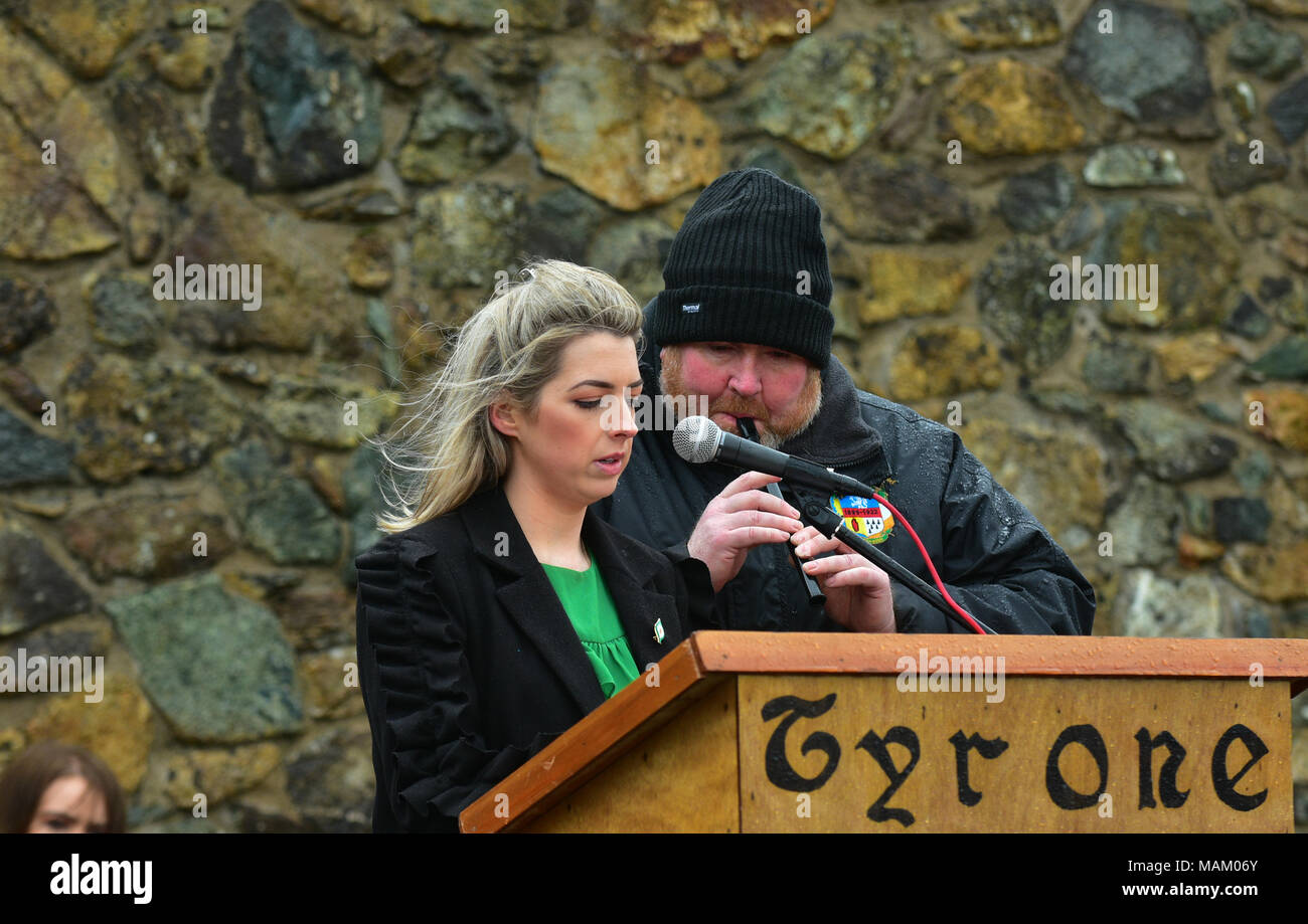 Carrickmore, UK. 2nd April, 2018. Siobhan O'Donnell reads the Roll of Honour accompained on the Irish whistle by Aidy Devlin at the Tyrone National Graves Association annual Commemoration which took place in Carrickmore, on Easter Monday, upwards of 300 people attended the annual remembrance. Tyrone: UK: 2nd April 2018 Credit: Mark Winter/Alamy Live News Stock Photo