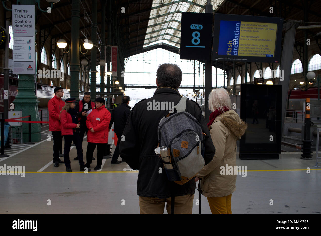 Couple wait for information about their journey after trains are cancelled due to train strikes, Gare de Nord, Paris, France Stock Photo