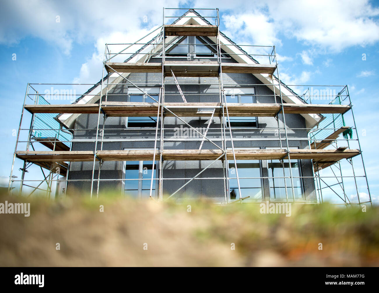 21 March 2018, Germany, Leiferde: A house' shell construction surrounded by scaffolding in a new residential area. Photo: Hauke-Christian Dittrich/dpa Stock Photo