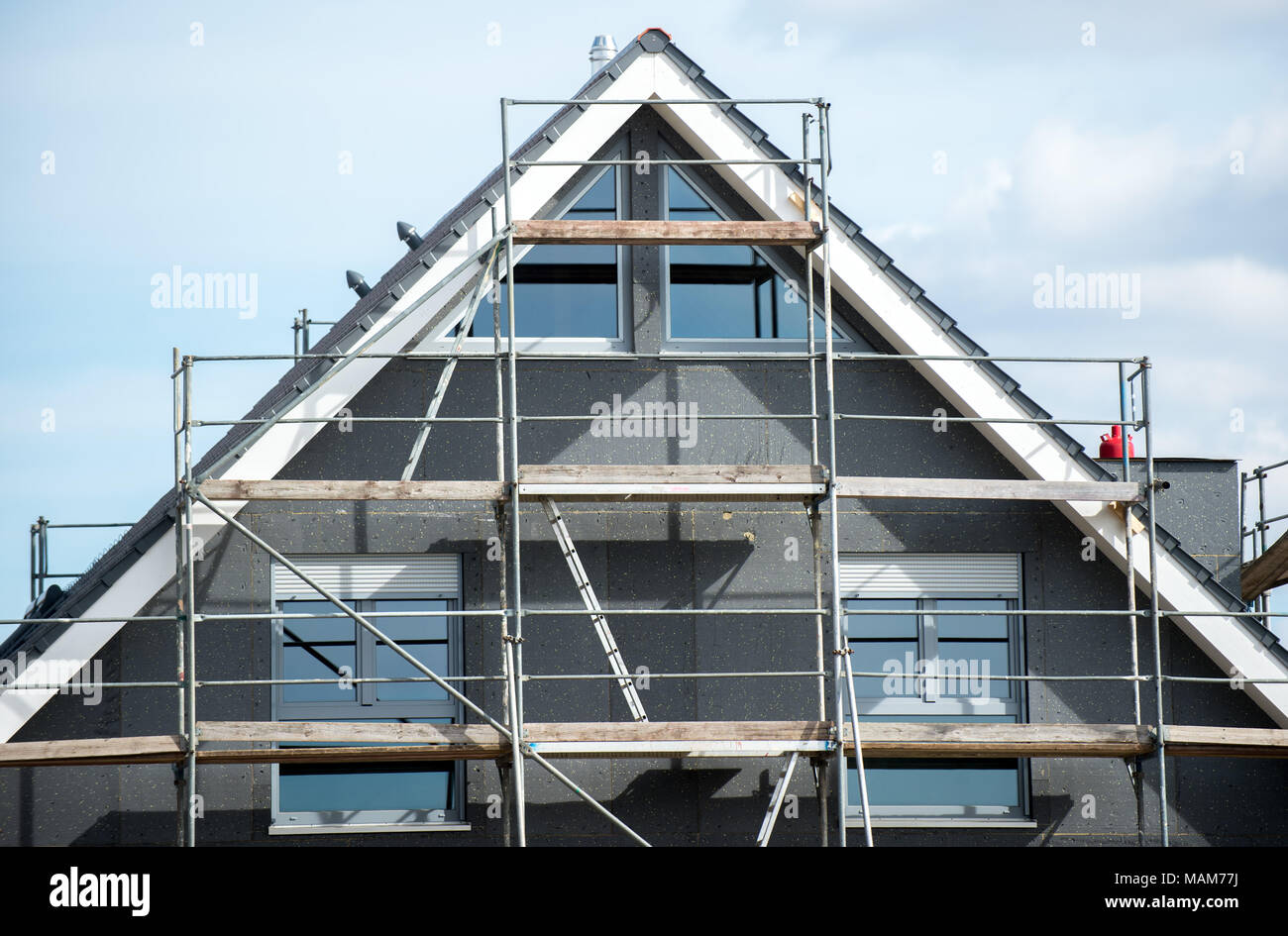 21 March 2018, Germany, Leiferde: A house' shell construction surrounded by scaffolding in a new residential area. Photo: Hauke-Christian Dittrich/dpa Stock Photo