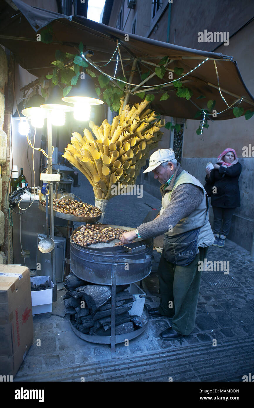 Rome, Italy - November 18, 2017 The seller of chestnuts at night in the light of lanterns Stock Photo
