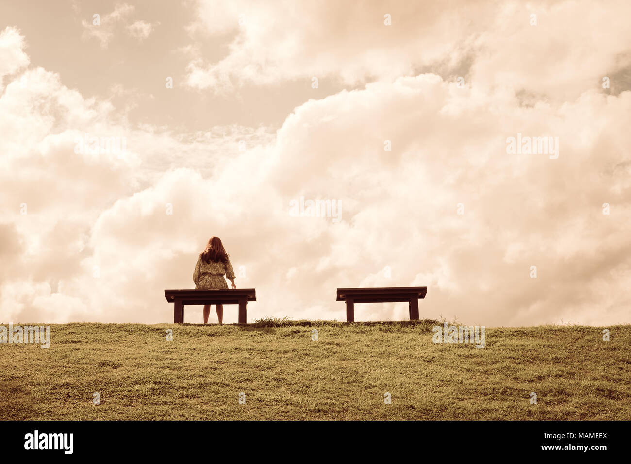 a women sitting alone on a bench waiting for love, alone concept Stock Photo