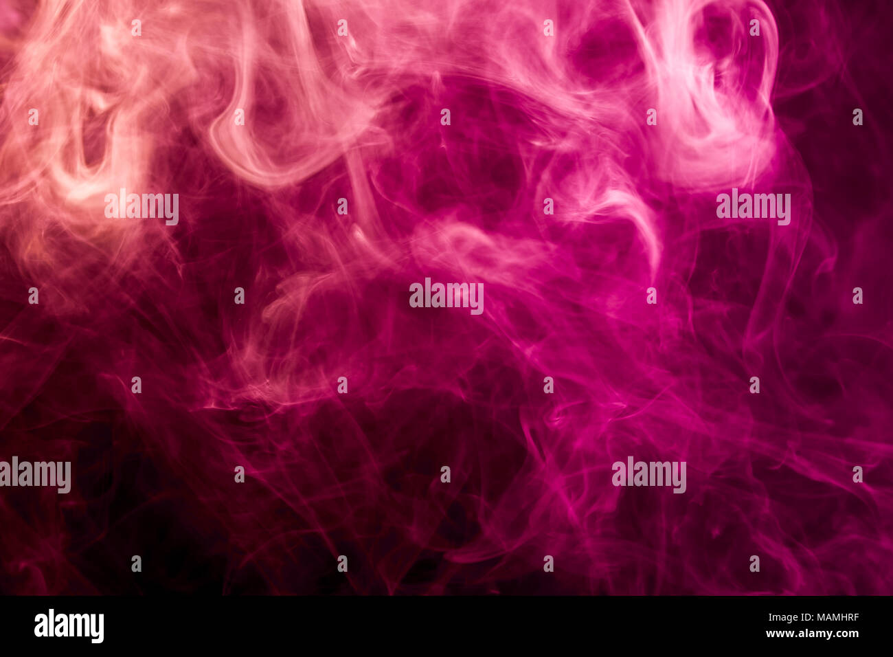 Dense multicolored smoke of red and pink colors on a black isolated