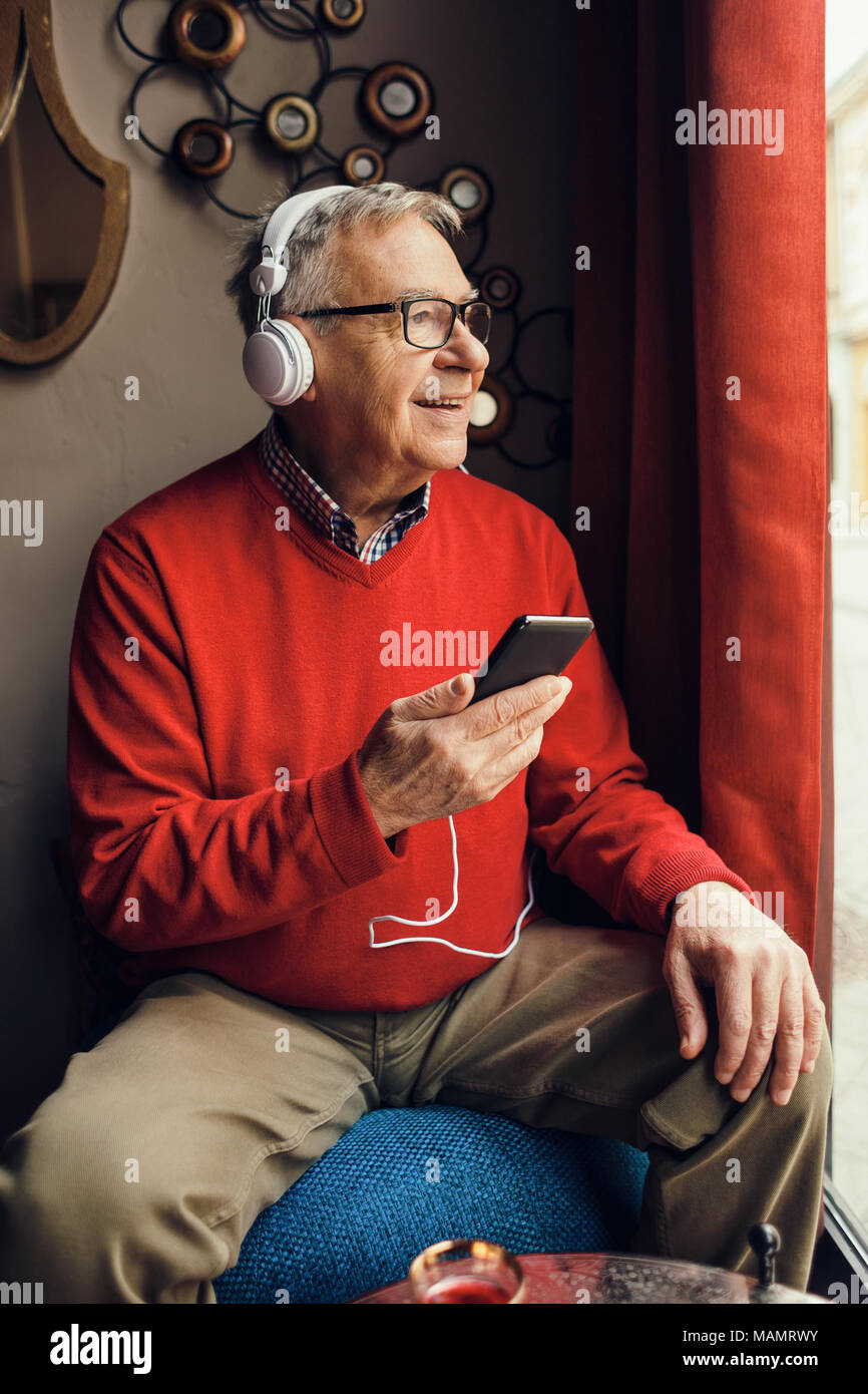 Senior man is sitting in cafe and chatting. Stock Photo