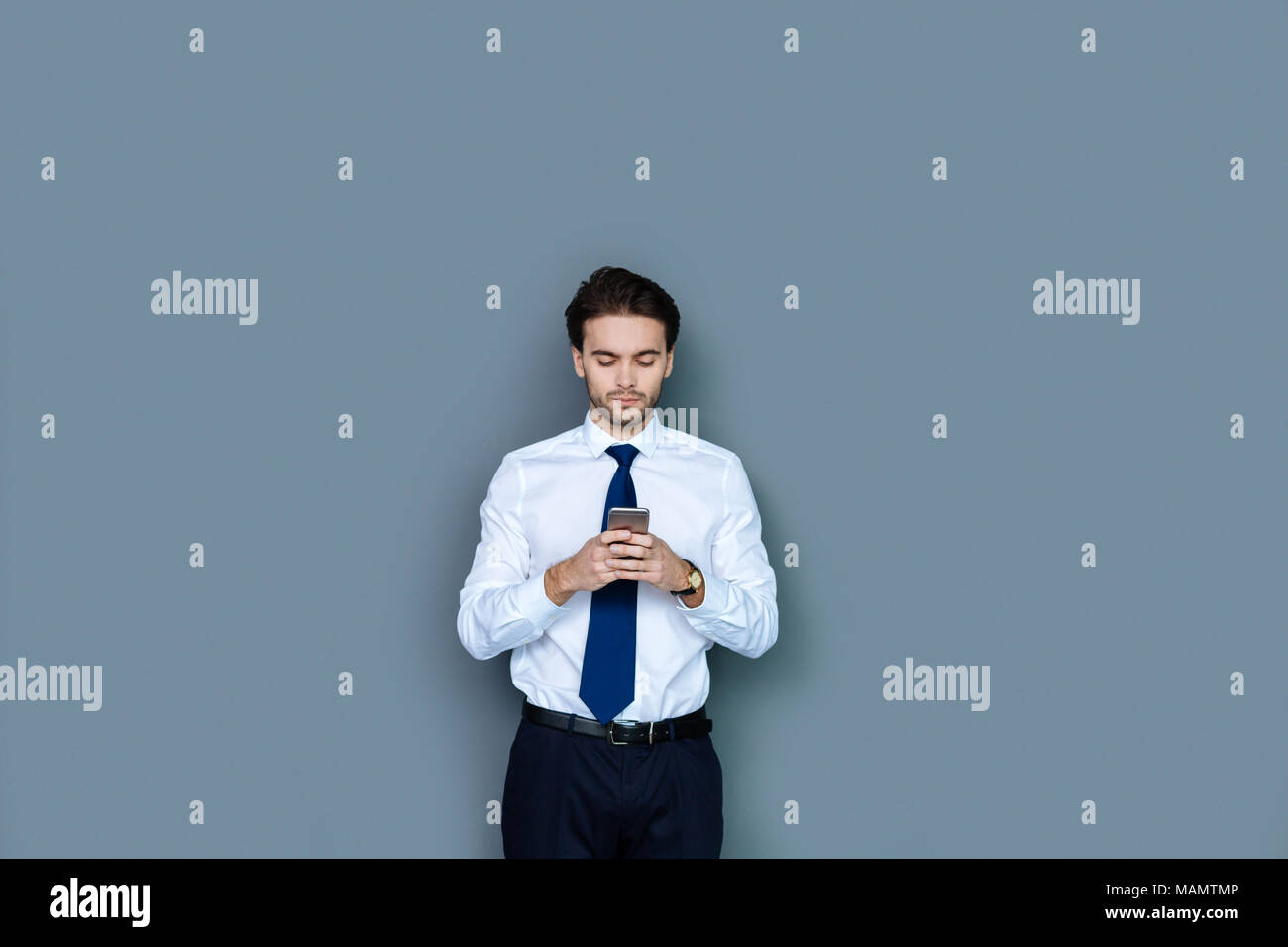 Smart nice businessman using his smartphone Stock Photo