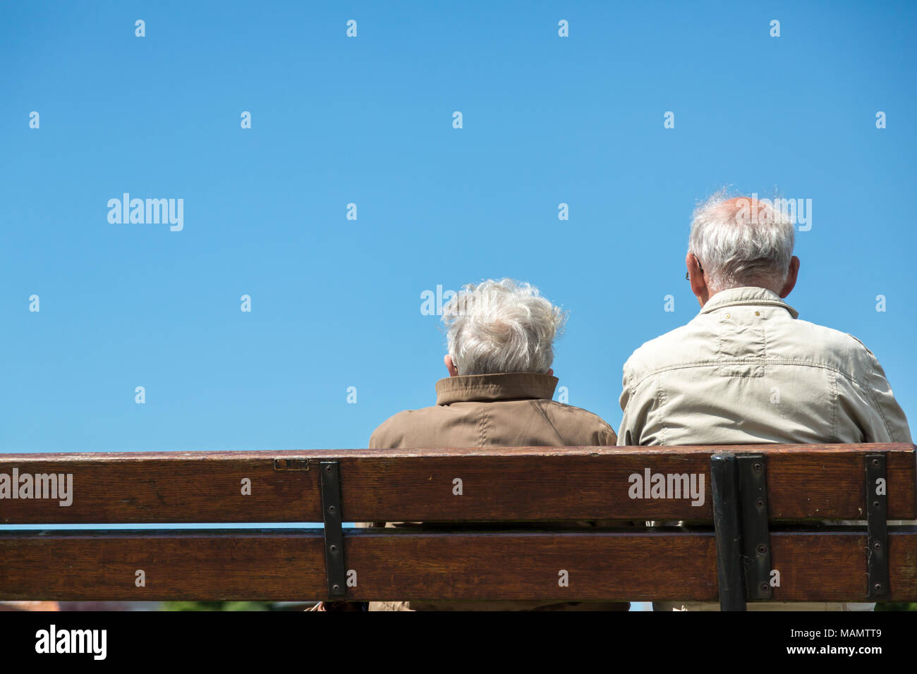 Greetsiel, Germany, retired couple sitting on a bench Stock Photo