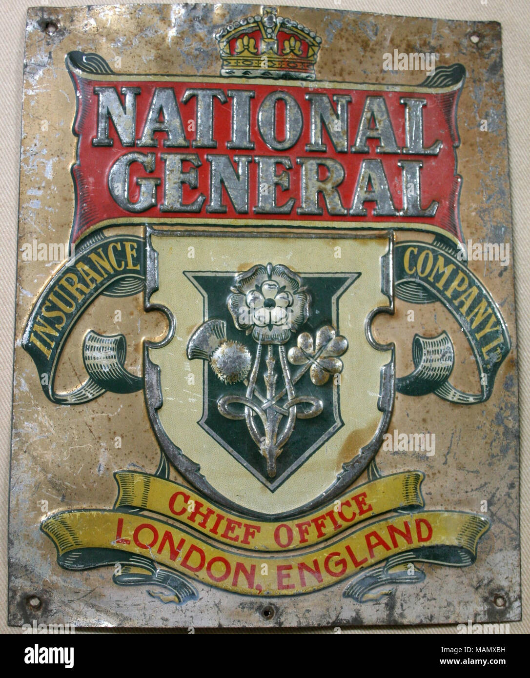 Pressed tin fire mark for National General Insurance Company, Limited in  London, England showing crown at top of mark; shield in center with images  of rose, shamrock and thistle; lettering around shield, image size:1086x1390