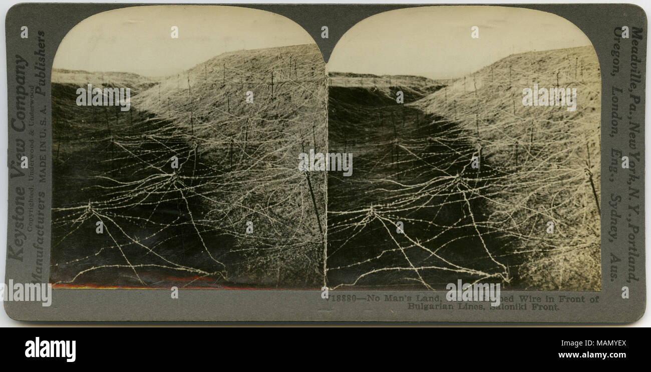 Horizontal, sepia stereocard showing a hill and a ditch covered in barbed wire. Keystone Stereograph number V18880. The title reads: 'No Man's Land, Sea of Barbed Wire in Front of Bulgarian Lines, Saloniki Front.' Title: 'Sea of Barbed Wire in Front of Bulgarian Lines, Saloniki.'  . between circa 1915 and circa 1918. Keystone View Company Stock Photo