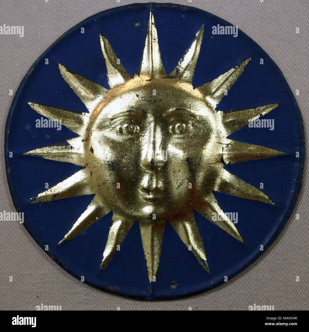 Tin fire mark for Sun Insurance Office in London, England showing gold sun with 16 rays alternating wavy and straight on blue background Title: Tin fire mark for Sun Insurance Office, Limited in London, England  . after 1710. Stock Photo