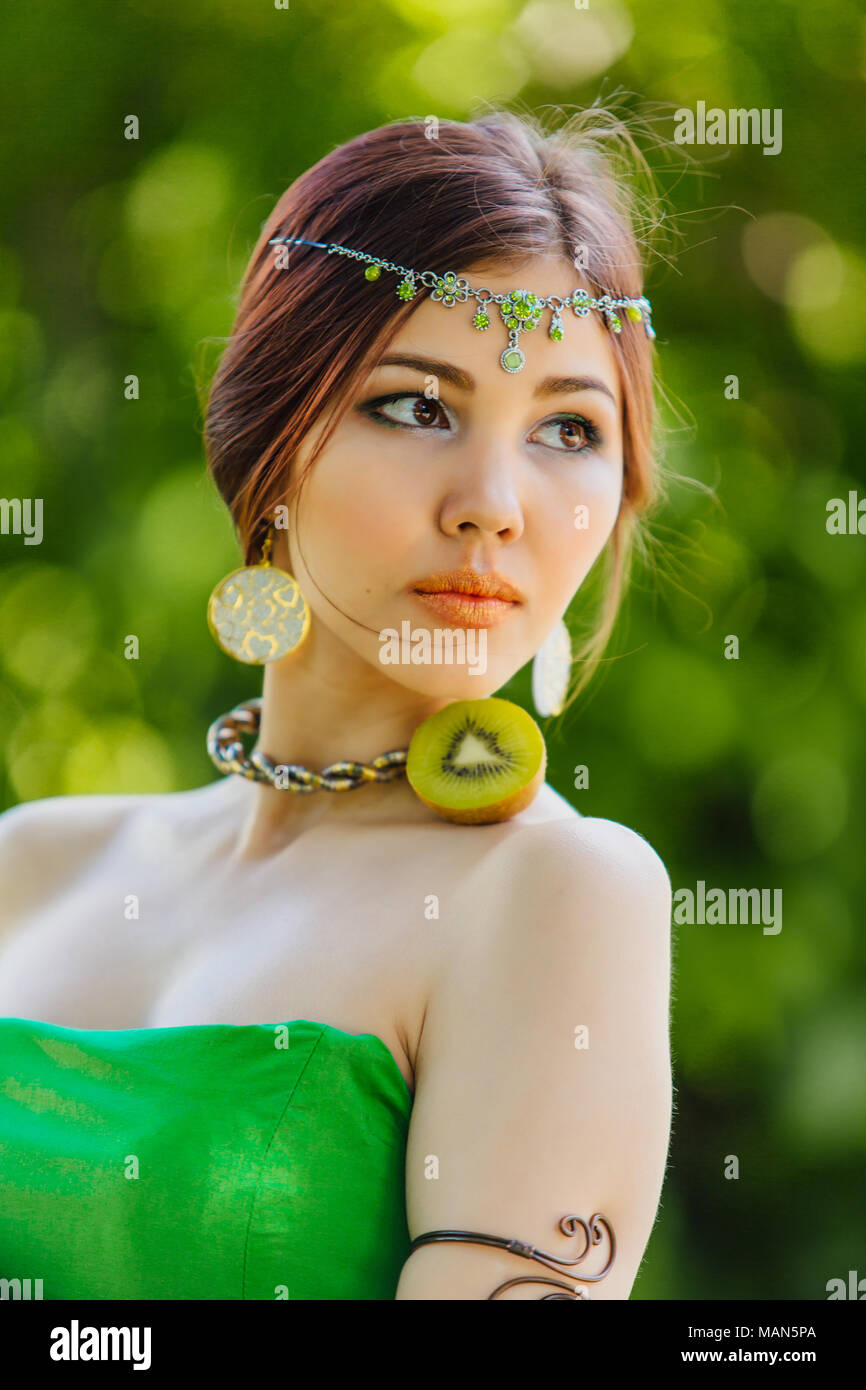 Portrait of a beautiful young asian woman holding half of kiwi Stock ...
