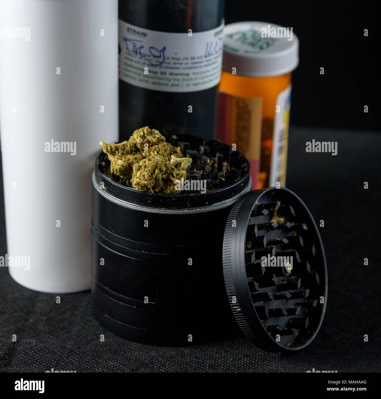 prescription bottles of medical marijuana next to a grinder with buds. Black background Stock Photo